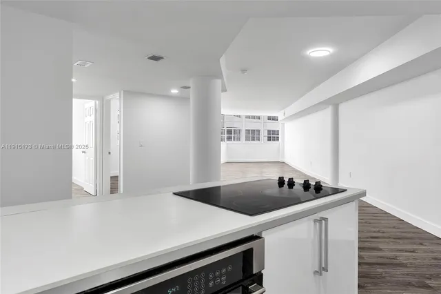 a kitchen that has a sink a stove and cabinets