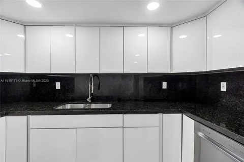 a kitchen with granite countertop cabinets and black appliances