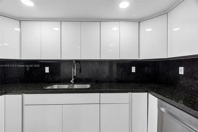 a kitchen with granite countertop cabinets and black appliances