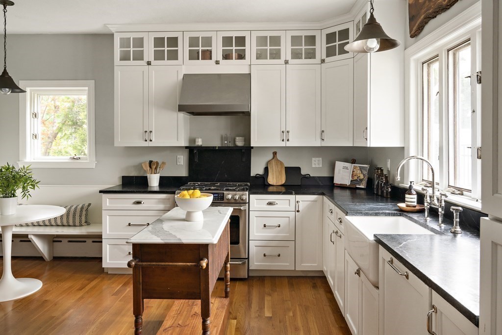 a kitchen with a stove white cabinets and white appliances