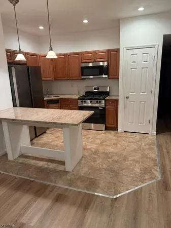 a kitchen with stainless steel appliances a refrigerator a stove a sink and a oven