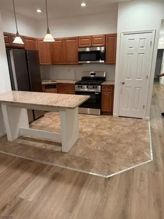 a kitchen with stainless steel appliances a refrigerator a stove a microwave and cabinets