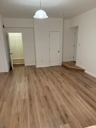 a view of an empty room and wooden floor