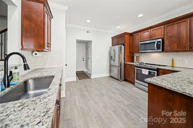 a kitchen with stainless steel appliances granite countertop a sink refrigerator and microwave