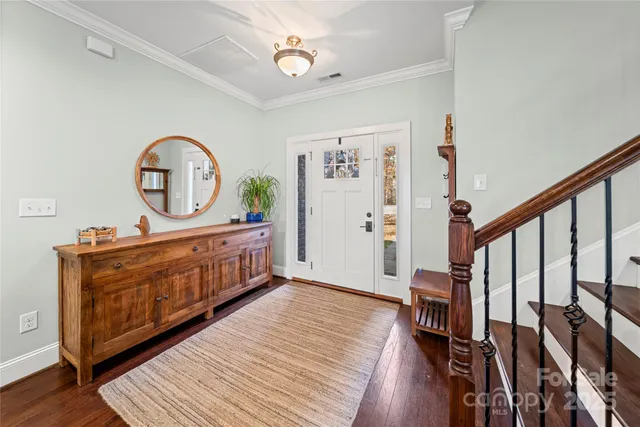 a view of a hallway with wooden floor and front door