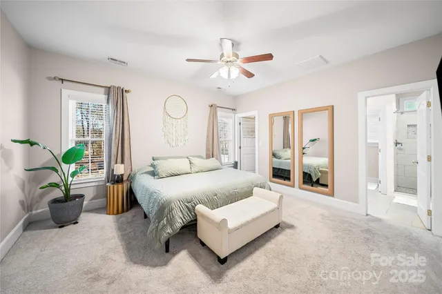 a spacious bedroom with a balcony a bed a chandelier and a window