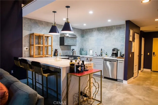 a kitchen with stainless steel appliances granite countertop a sink a stove and chairs