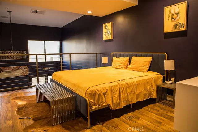 a bedroom with a bed and wooden floor