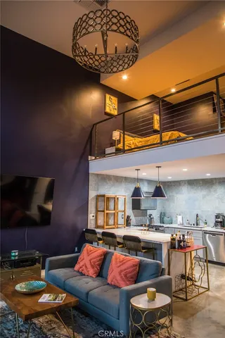 a living room with furniture a flat screen tv and kitchen view