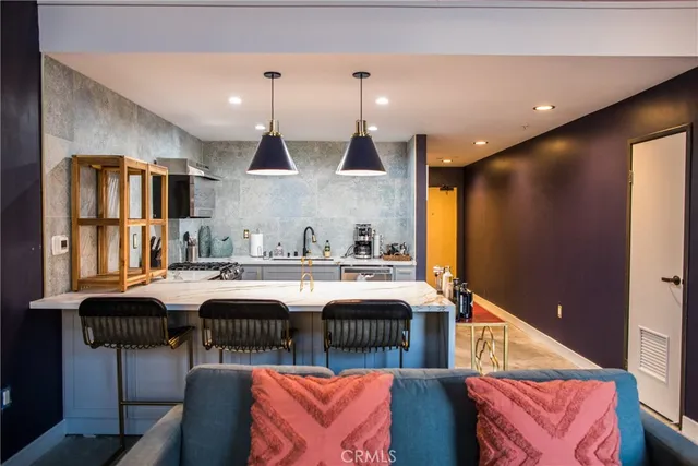 a kitchen with stainless steel appliances granite countertop a sink and a refrigerator