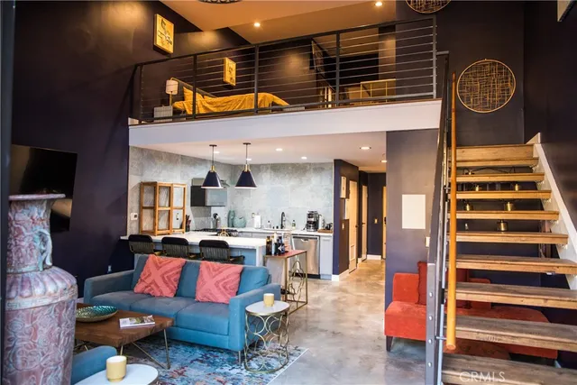 a living room with lots of furniture and paintings on the wall