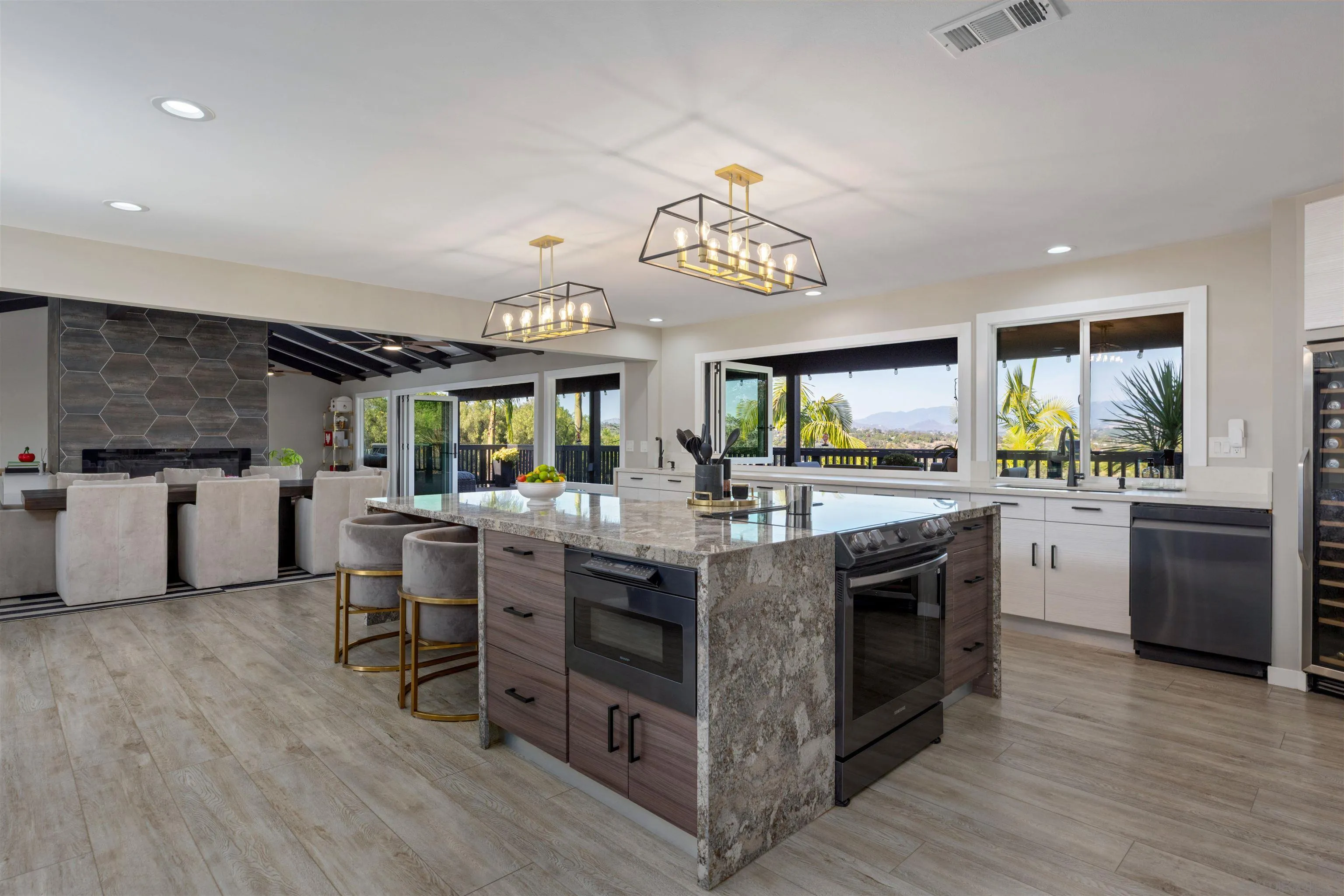 521 Rancho Camino Fallbrook, CA 92028 - Photo 15 of 72 a kitchen with stainless steel appliances granite countertop wooden floors and white cabinets