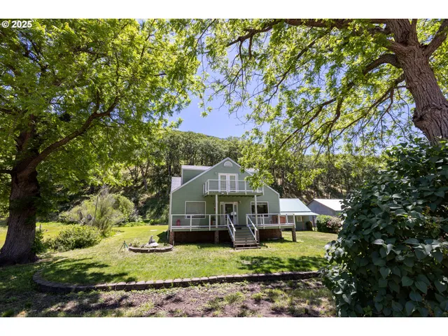 a view of a yard in front of a house with large windows
