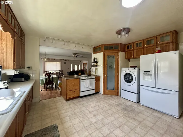 a large kitchen with a large counter top stainless steel appliances and cabinets
