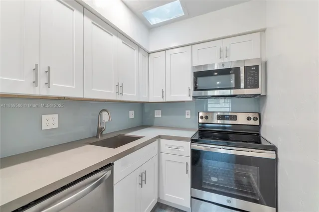 a kitchen with stainless steel appliances a stove microwave and cabinets