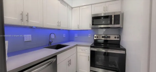 a kitchen with stainless steel appliances a stove a microwave and cabinets