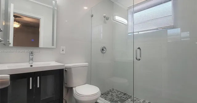 a bathroom with a sink a toilet and shower