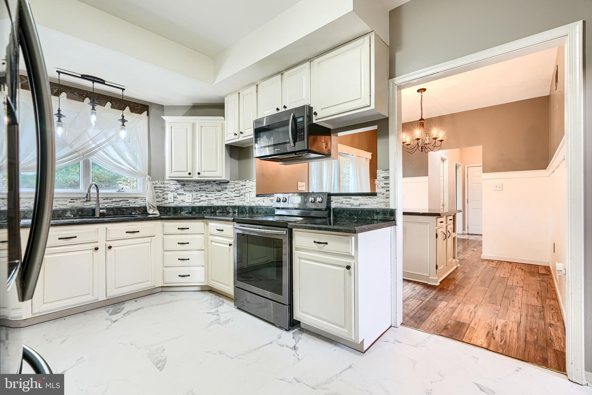 544 Elk Mills Road Elkton, MD 21921 - Photo 14 of 65 a kitchen with granite countertop white cabinets and white appliances
