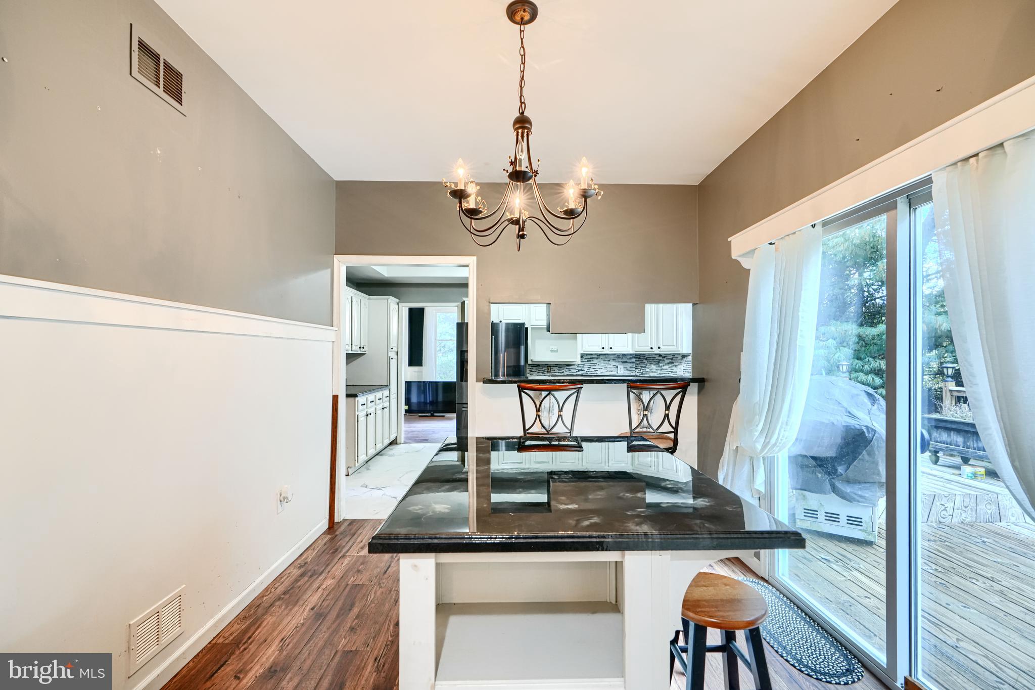 544 Elk Mills Road Elkton, MD 21921 - Photo 23 of 65 a dining room with wooden floor a chandelier a wooden table and chairs