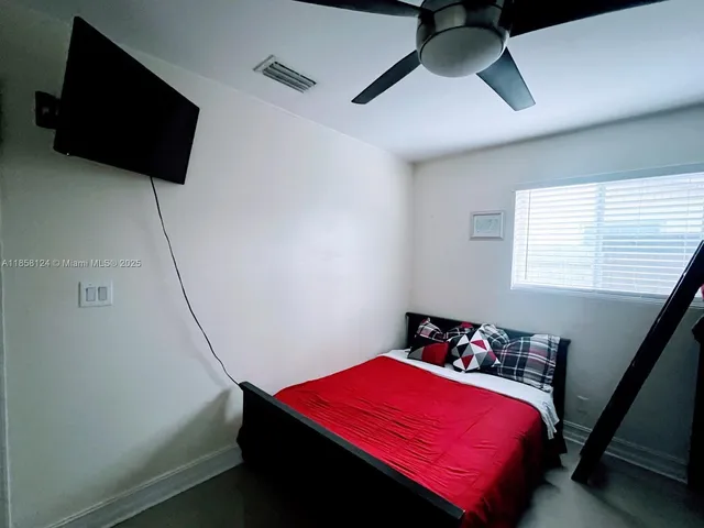 a bedroom with a bed and a flat tv screen