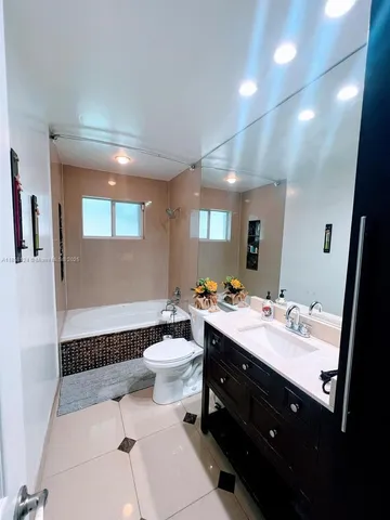 a bathroom with a double vanity sink toilet and mirror
