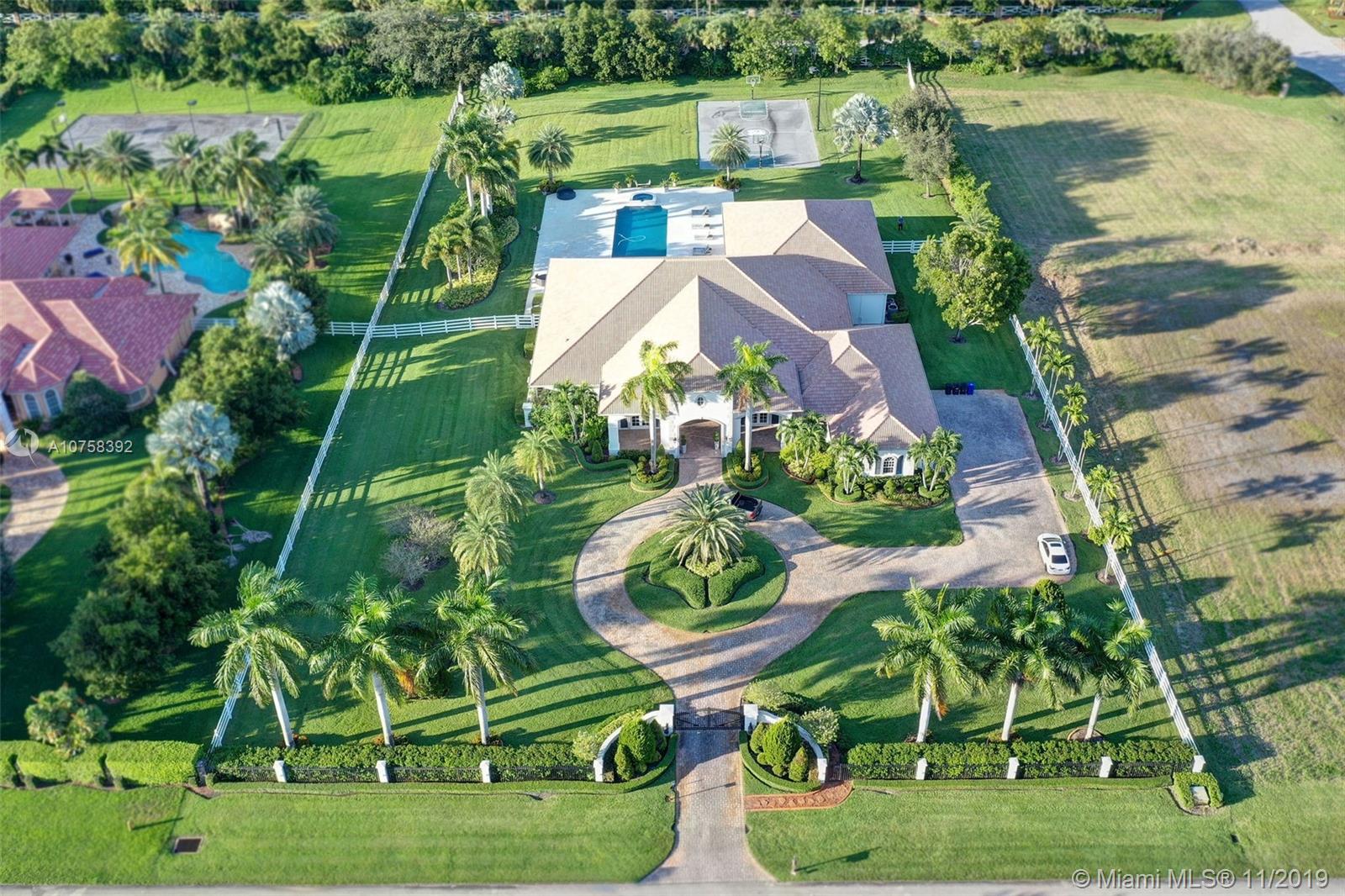 an aerial view of a house with a yard and lake view in back yard