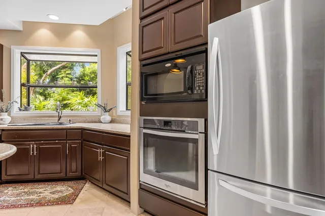 a kitchen with granite countertop a refrigerator and a sink