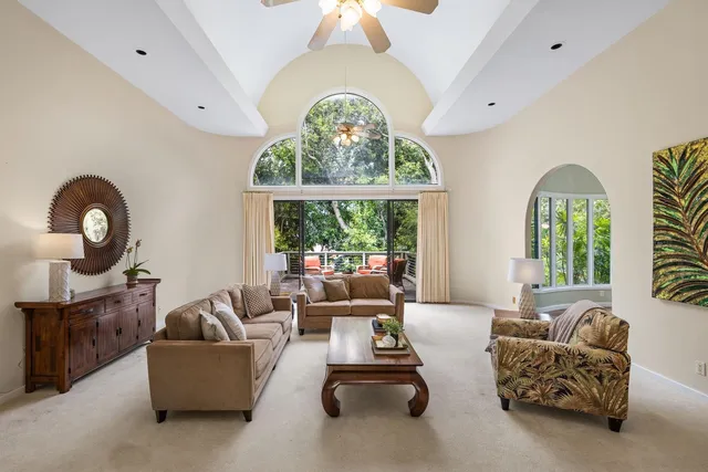 a living room with furniture a large window and a chandelier