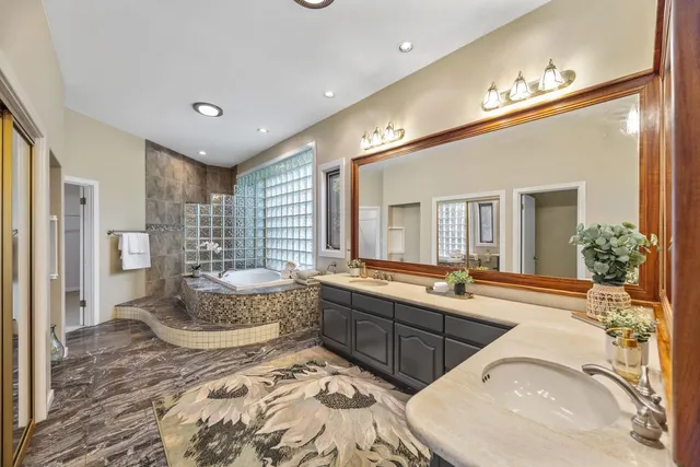 a large bathroom with double vanity sinks a bathtub and a shower