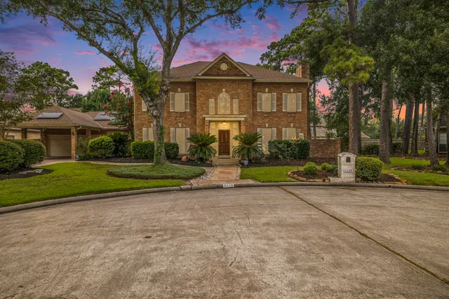 a front view of a house with a yard and trees