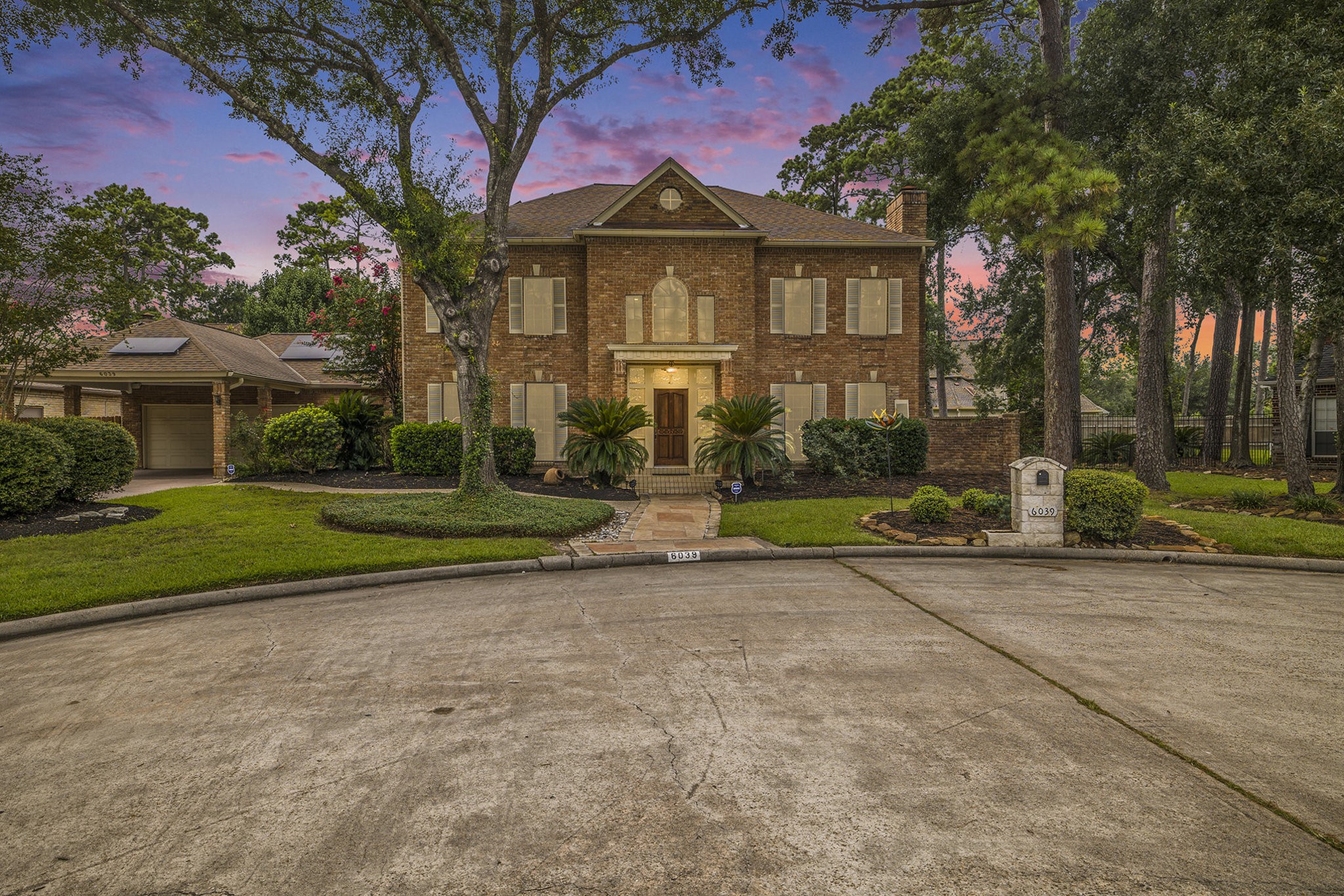 a front view of a house with a yard and trees