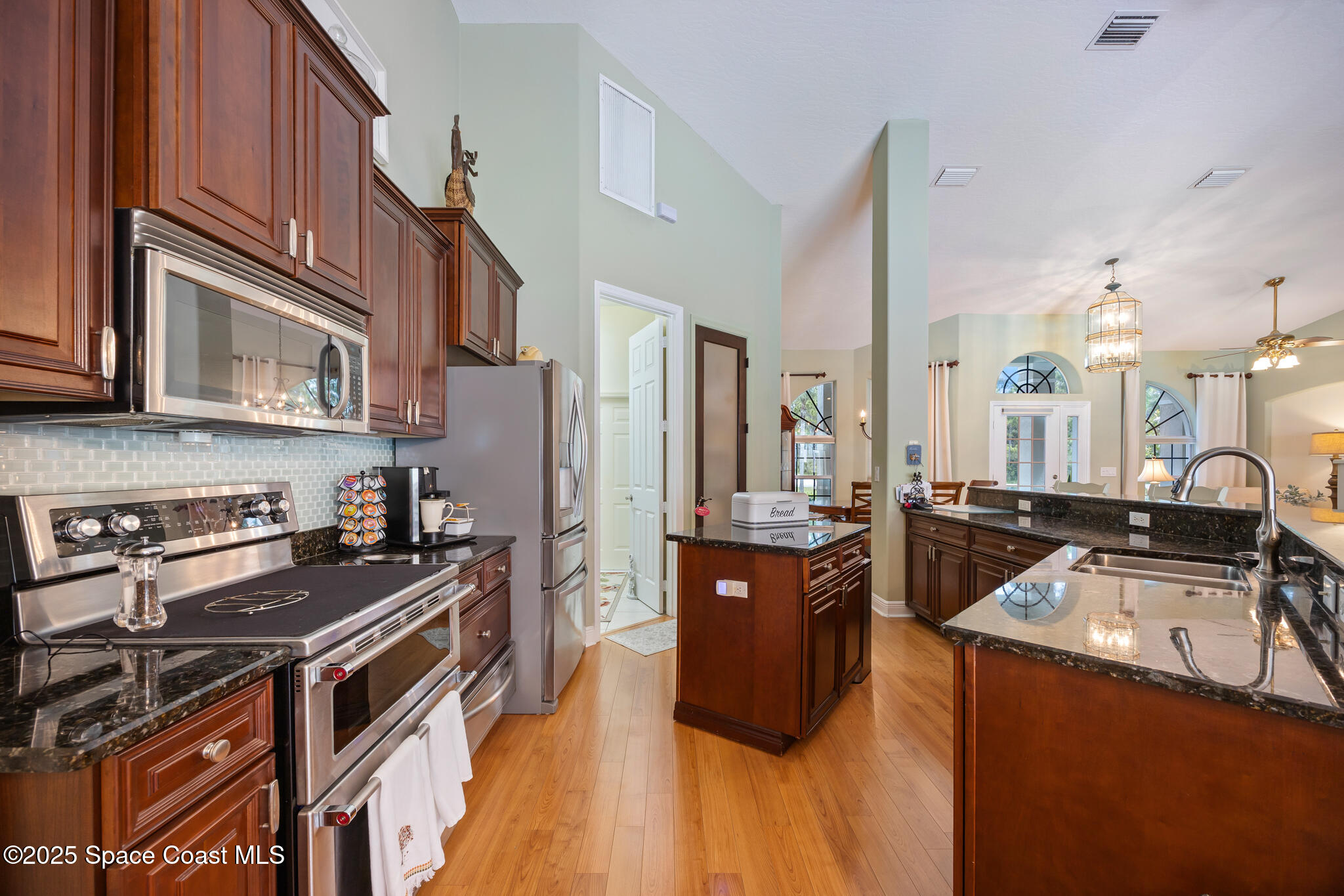 7210 Wando Avenue Grant, FL 32949 - Photo 16 of 41 a kitchen with stainless steel appliances a stove a sink a refrigerator and cabinets
