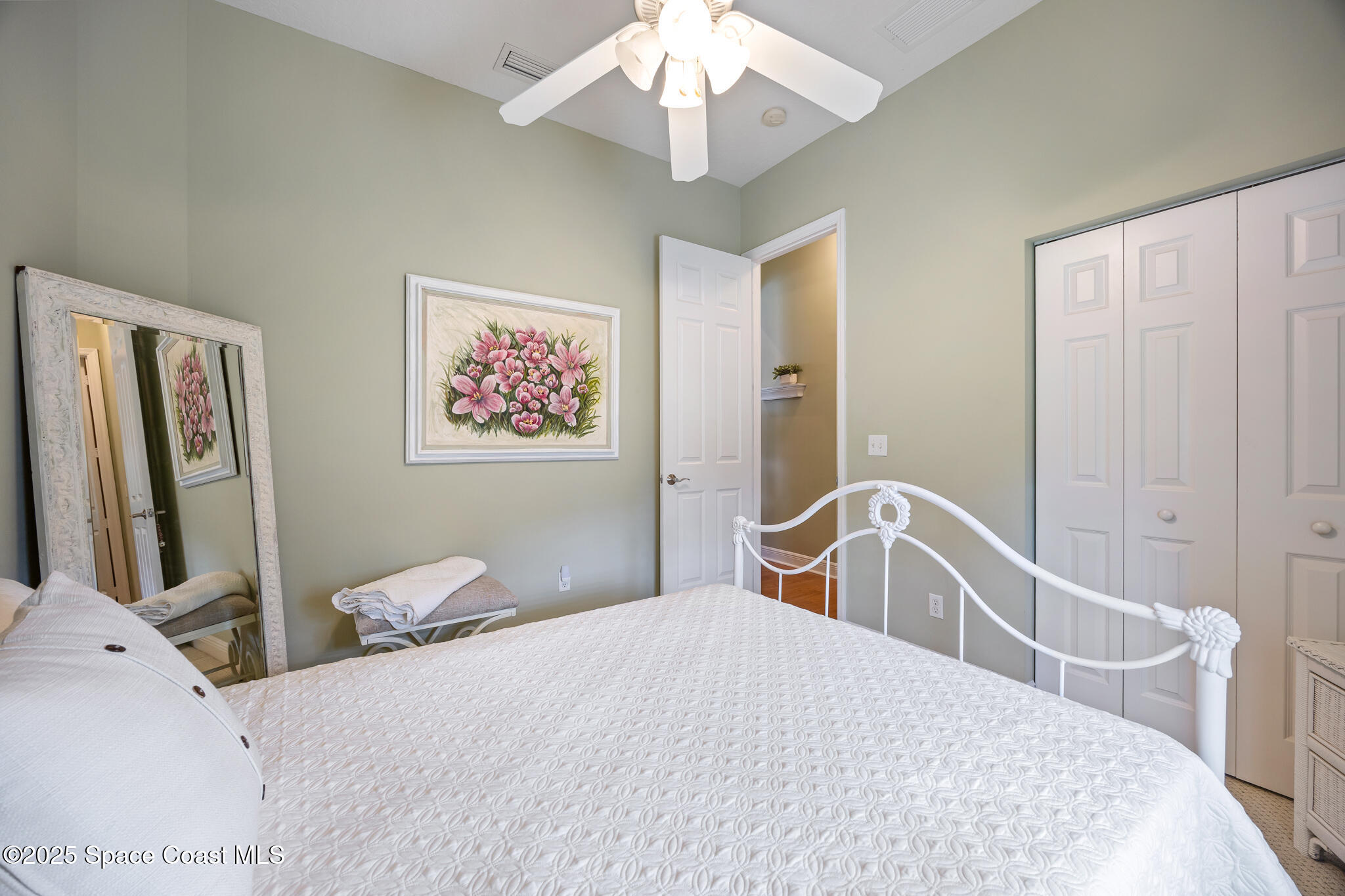 7210 Wando Avenue Grant, FL 32949 - Photo 19 of 41 a bedroom with a large bed and a chandelier
