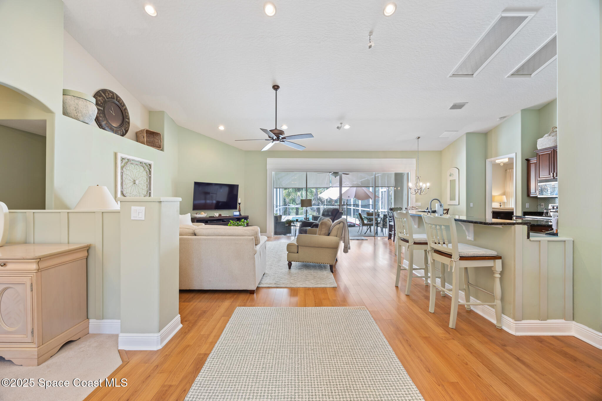7210 Wando Avenue Grant, FL 32949 - Photo 10 of 41 a living room with furniture a flat screen tv and kitchen view