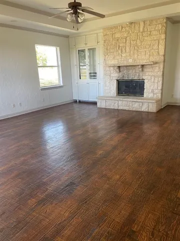 an empty room with windows and fireplace