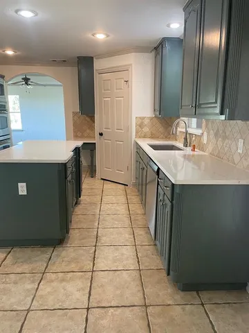 a kitchen with a sink a counter top space and cabinets