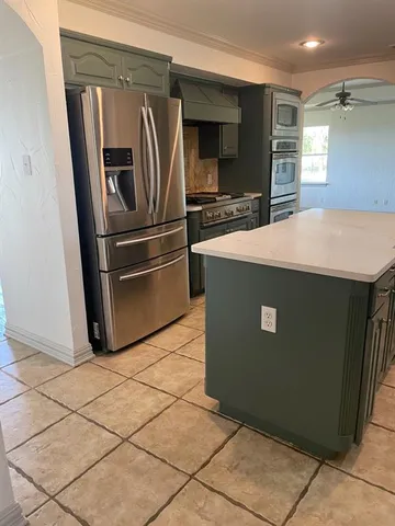 a kitchen with granite countertop a refrigerator and a stove