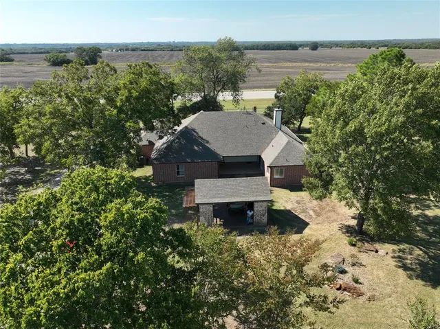 an aerial view of a house with a yard and lake view