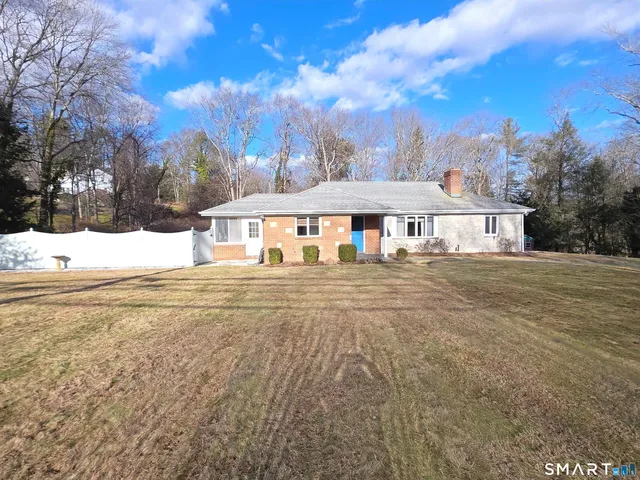 a view of a house with yard and sitting area