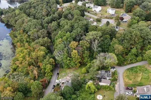 an aerial view of residential house with outdoor space and trees all around