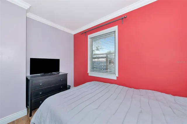 a view of a hallway with wooden floor and a bathroom