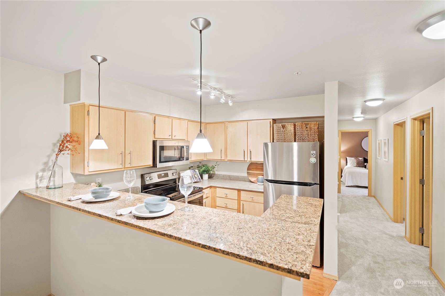 10709 Valley View Road, Unit B302 Bothell, WA 98011 - Photo 7 of 20 a kitchen with kitchen island granite countertop a sink and living room view