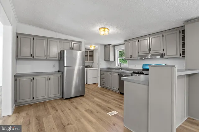 a view of kitchen with refrigerator microwave and stove
