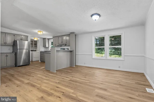 a view of a kitchen with wooden floor and a sink