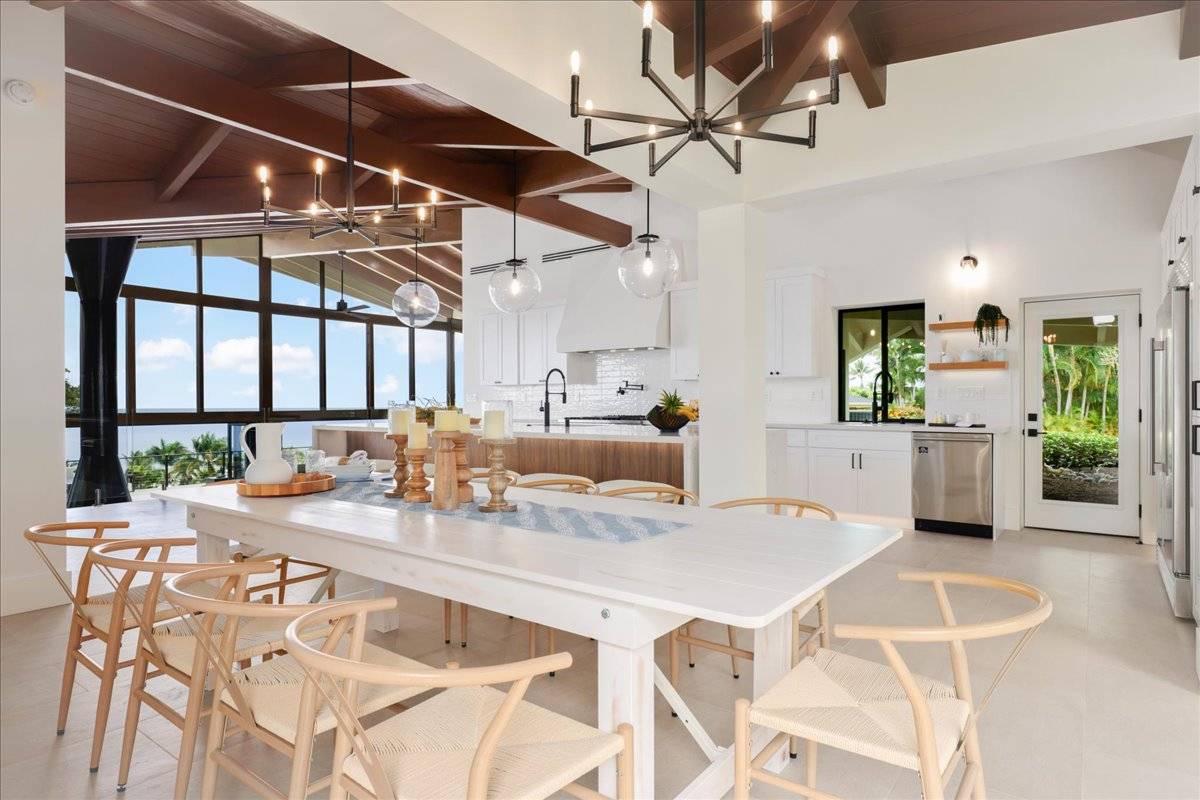 77-404 Pelenike Drive Kailua-Kona, HI 96740 - Photo 11 of 27 a kitchen with a table chairs and white cabinets
