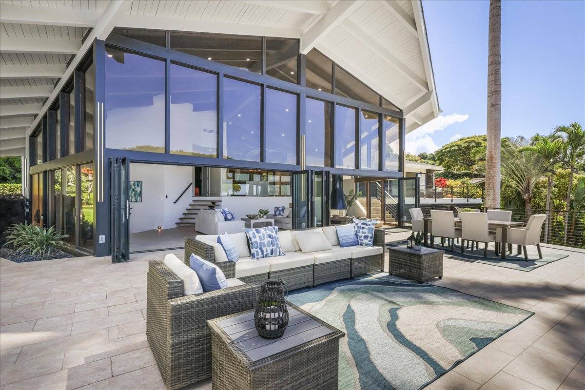 77-404 Pelenike Drive Kailua-Kona, HI 96740 - Photo 19 of 27 a view of a patio with couches table and chairs potted plants and large tree