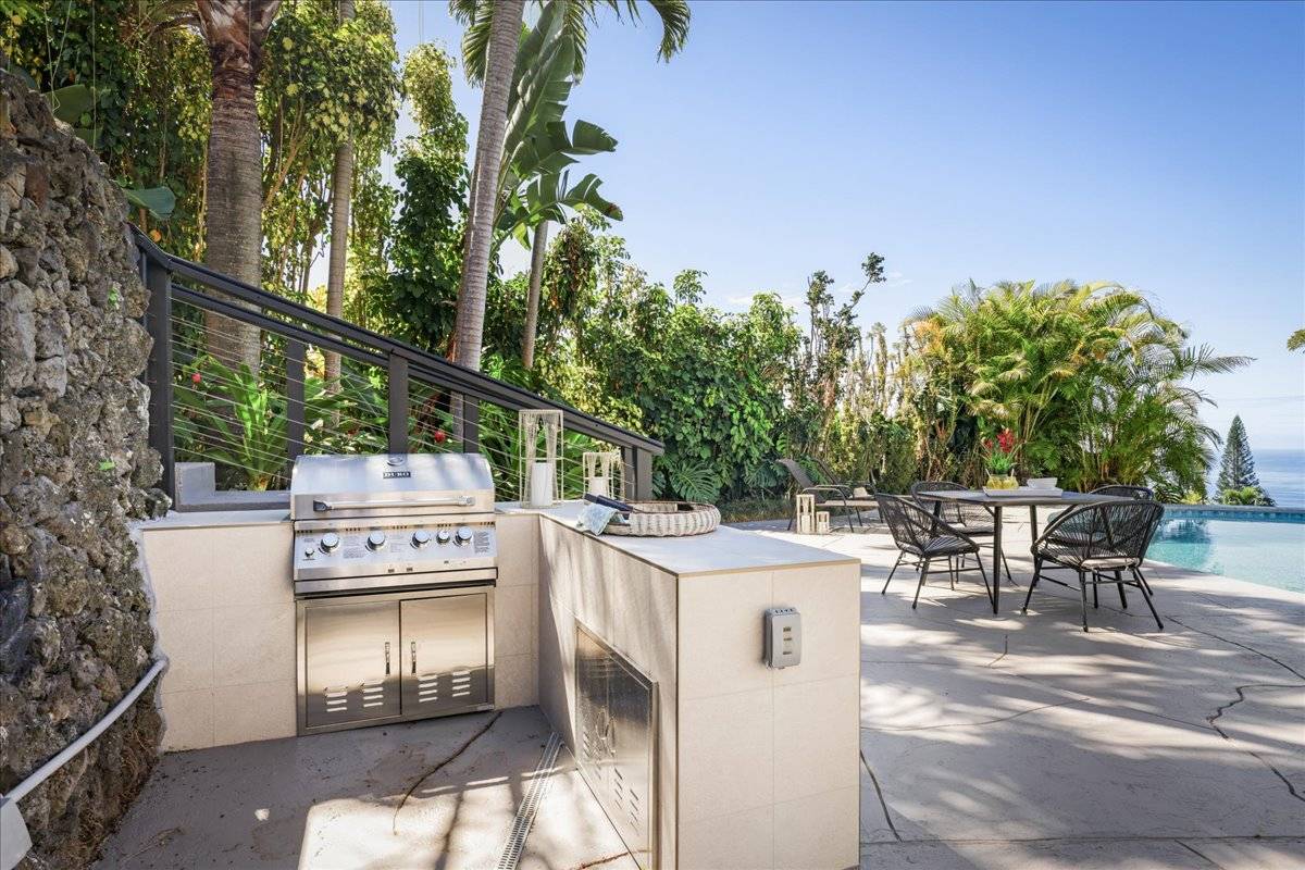 77-404 Pelenike Drive Kailua-Kona, HI 96740 - Photo 22 of 27 a view of a patio with table and chairs and potted plants