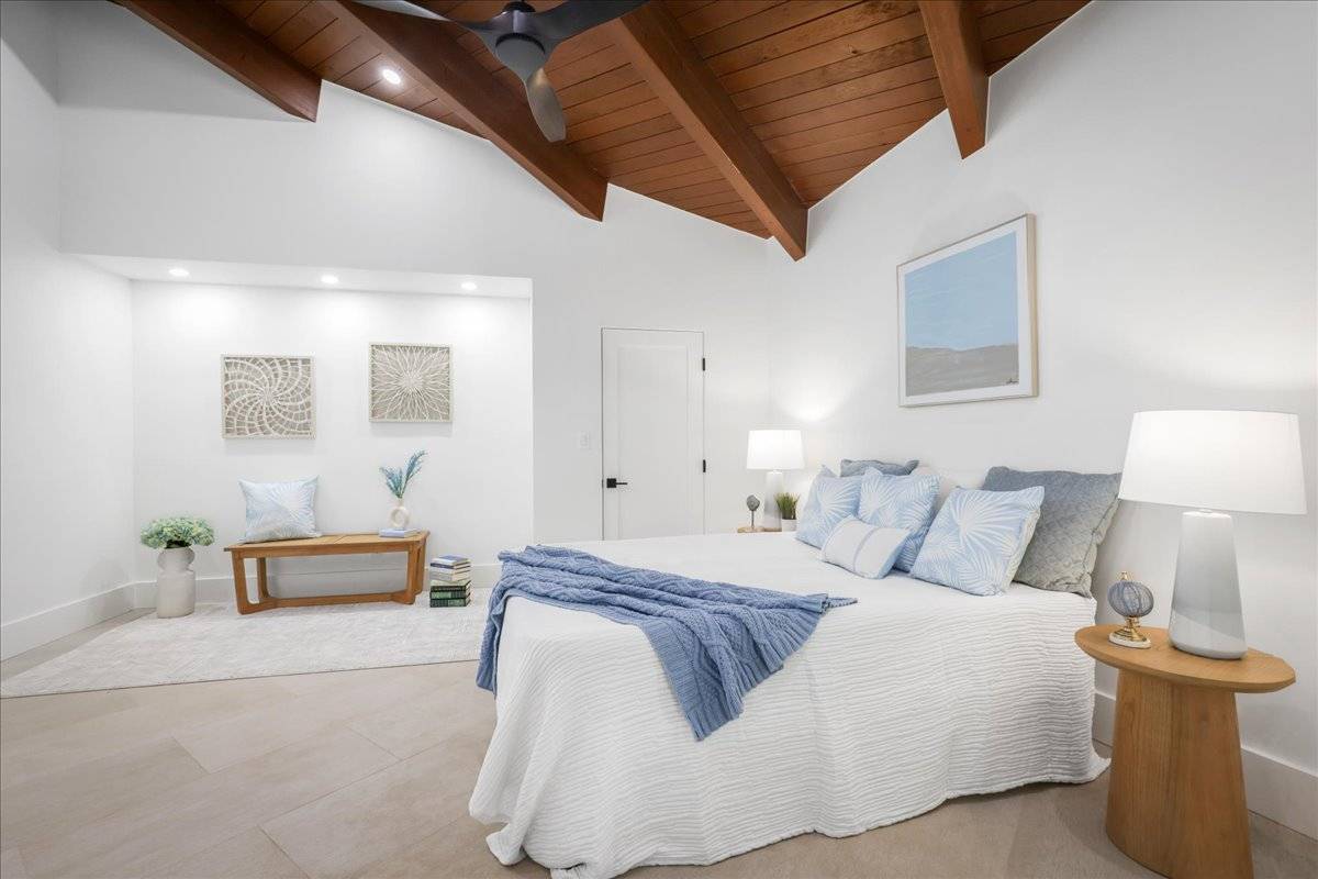 77-404 Pelenike Drive Kailua-Kona, HI 96740 - Photo 23 of 27 a spacious bedroom with a bed and lamp