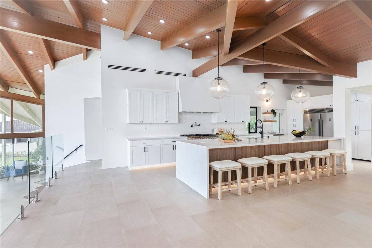77-404 Pelenike Drive Kailua-Kona, HI 96740 - Photo 8 of 27 a large white kitchen with lots of counter space and windows