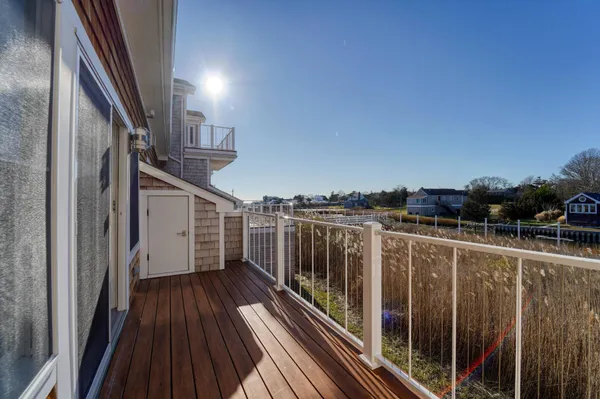 a view of balcony with wooden floor and fence